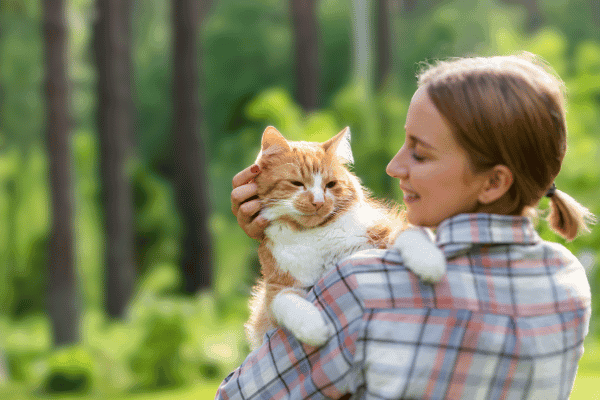 photo d'une femme tenant un chat sur son épaule